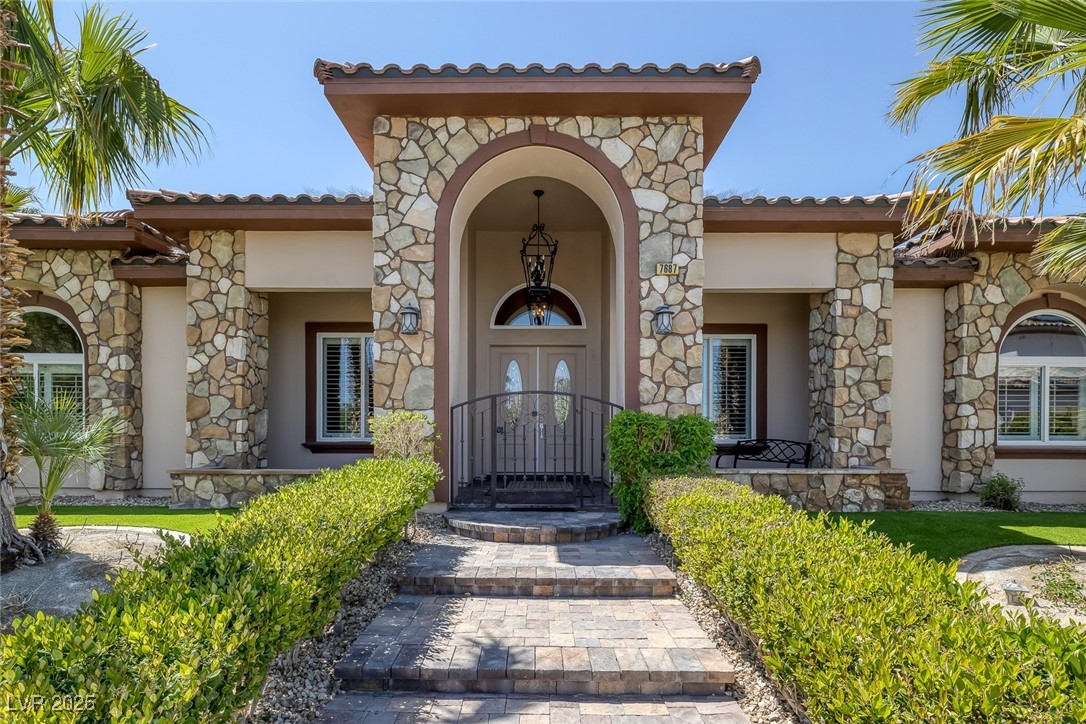 7687 West Pebble Road Las Vegas, NV 89113 - Photo 37 of 79 Property entrance featuring a porch, stucco siding, stone siding, and french doors