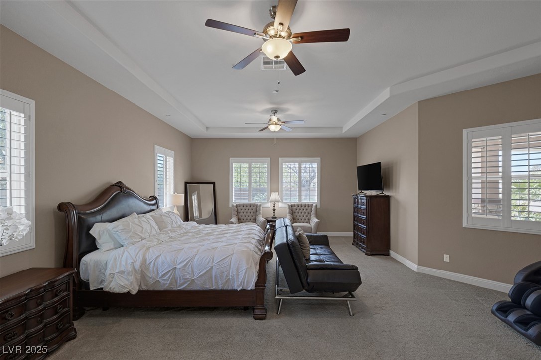 7687 West Pebble Road Las Vegas, NV 89113 - Photo 49 of 79 Bedroom with ceiling fan, visible vents, light carpet, a raised ceiling, and baseboards
