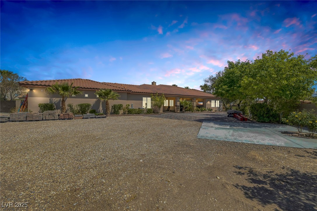 7687 West Pebble Road Las Vegas, NV 89113 - Photo 5 of 79 Rear view of property featuring stucco siding, a tiled roof, and a chimney
