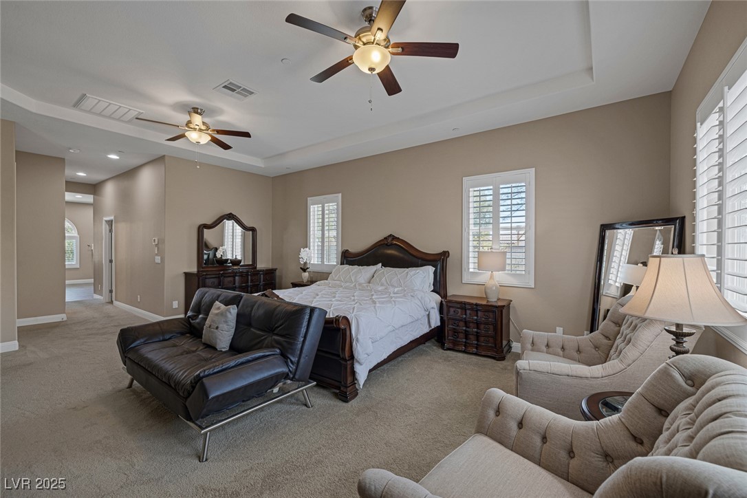 7687 West Pebble Road Las Vegas, NV 89113 - Photo 50 of 79 Bedroom with light carpet, visible vents, a tray ceiling, and baseboards