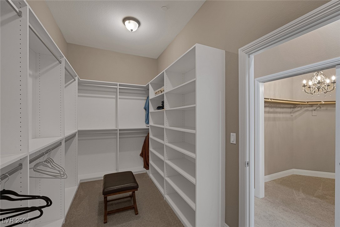7687 West Pebble Road Las Vegas, NV 89113 - Photo 53 of 79 Spacious closet featuring carpet floors and an inviting chandelier