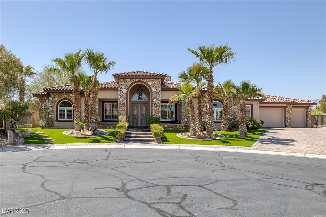 7687 West Pebble Road Las Vegas, NV 89113 - Photo 54 of 79 Mediterranean / spanish house featuring driveway, a tiled roof, a garage, and stone siding