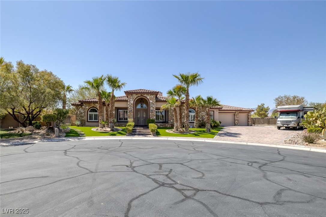 7687 West Pebble Road Las Vegas, NV 89113 - Photo 59 of 79 Mediterranean / spanish-style house with an attached garage, a tiled roof, driveway, and stucco siding