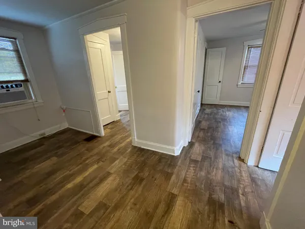 a view of a hallway with wooden floor and closet