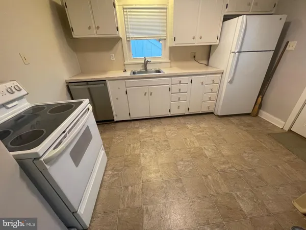 a kitchen with cabinets appliances and a sink