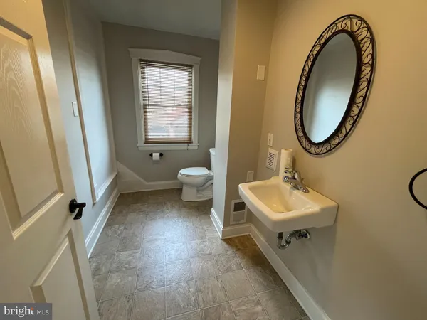 a bathroom with a sink toilet and a mirror