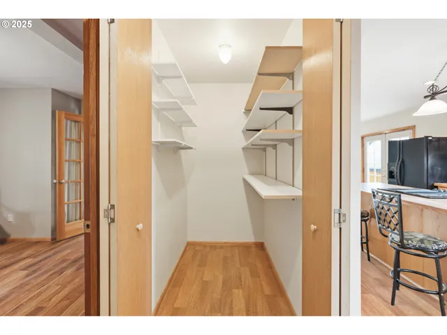 a view of a hallway with wooden floor and dining room