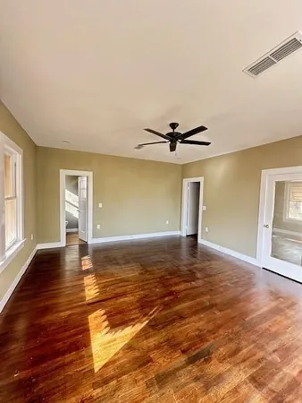 a view of a room with wooden floor window and a ceiling fan