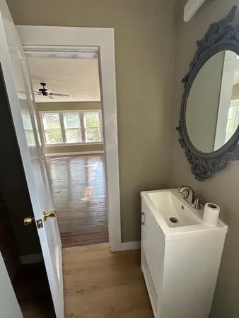 a bathroom with a sink and mirror with bathtub