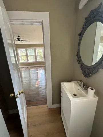 a bathroom with a sink and mirror with bathtub