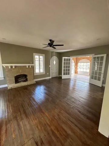 an empty room with wooden floor and a fireplace