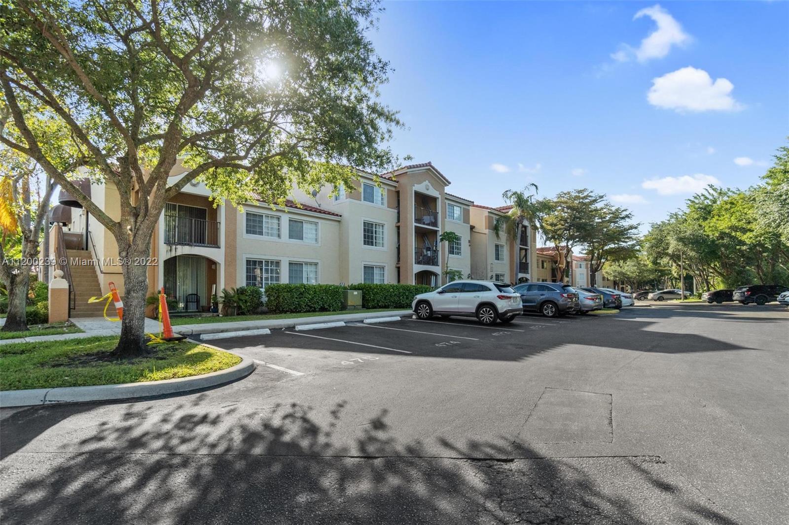 a view of a white house next to a road and yard
