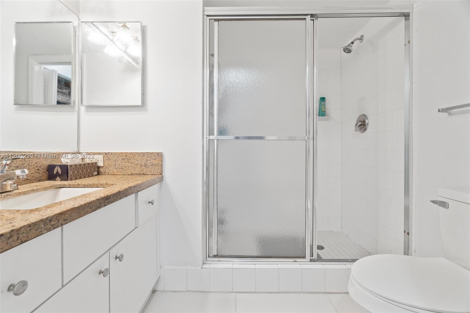 2071 Renaissance Boulevard, Unit 203 Miramar, FL 33025 - Photo 13 of 17 a bathroom with a granite countertop sink toilet and shower