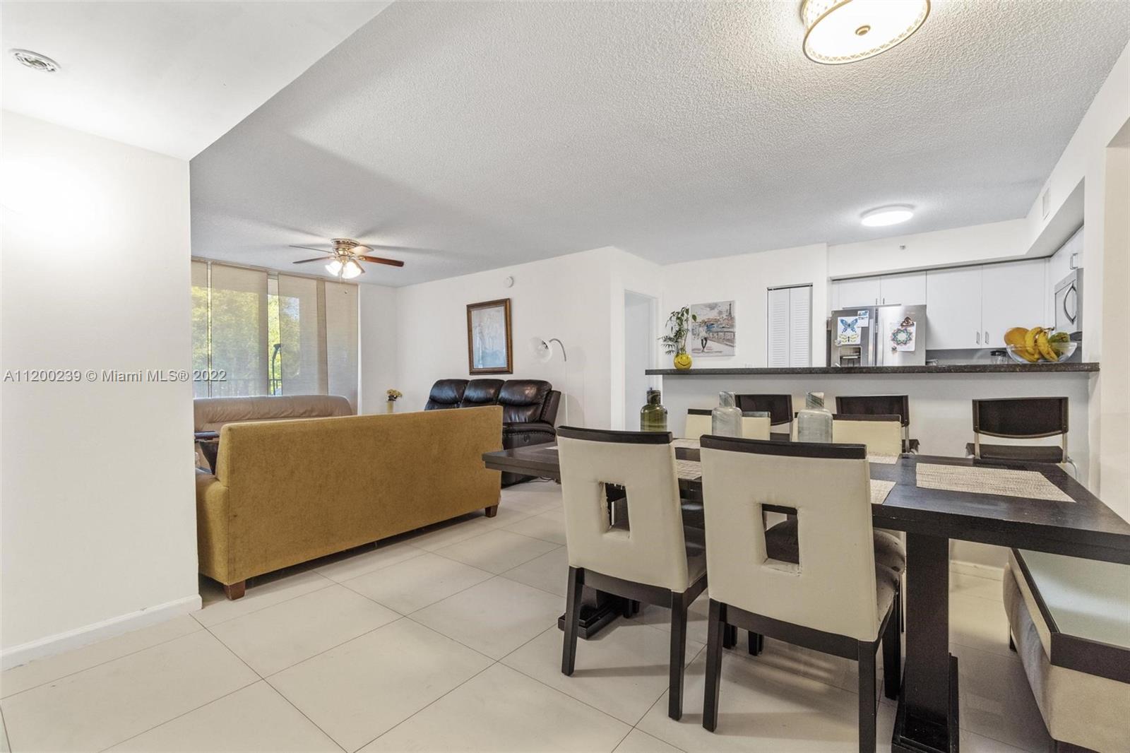 2071 Renaissance Boulevard, Unit 203 Miramar, FL 33025 - Photo 4 of 17 a living room with furniture and a kitchen view