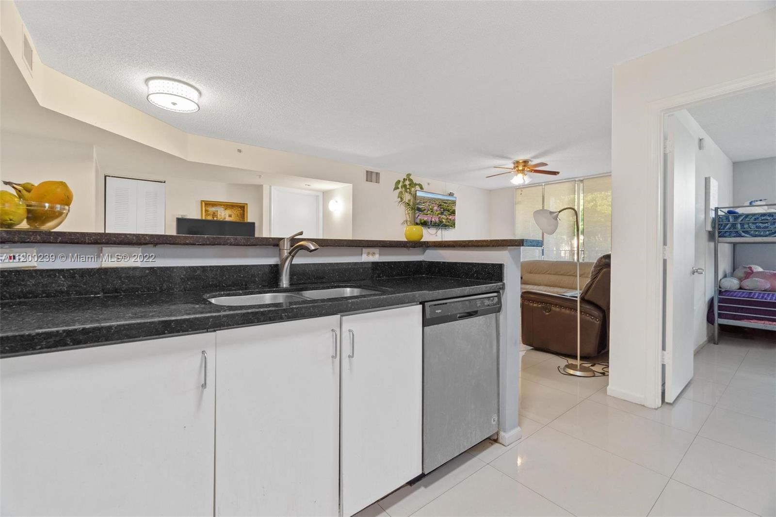 2071 Renaissance Boulevard, Unit 203 Miramar, FL 33025 - Photo 7 of 17 a kitchen with stainless steel appliances granite countertop a sink and a stove
