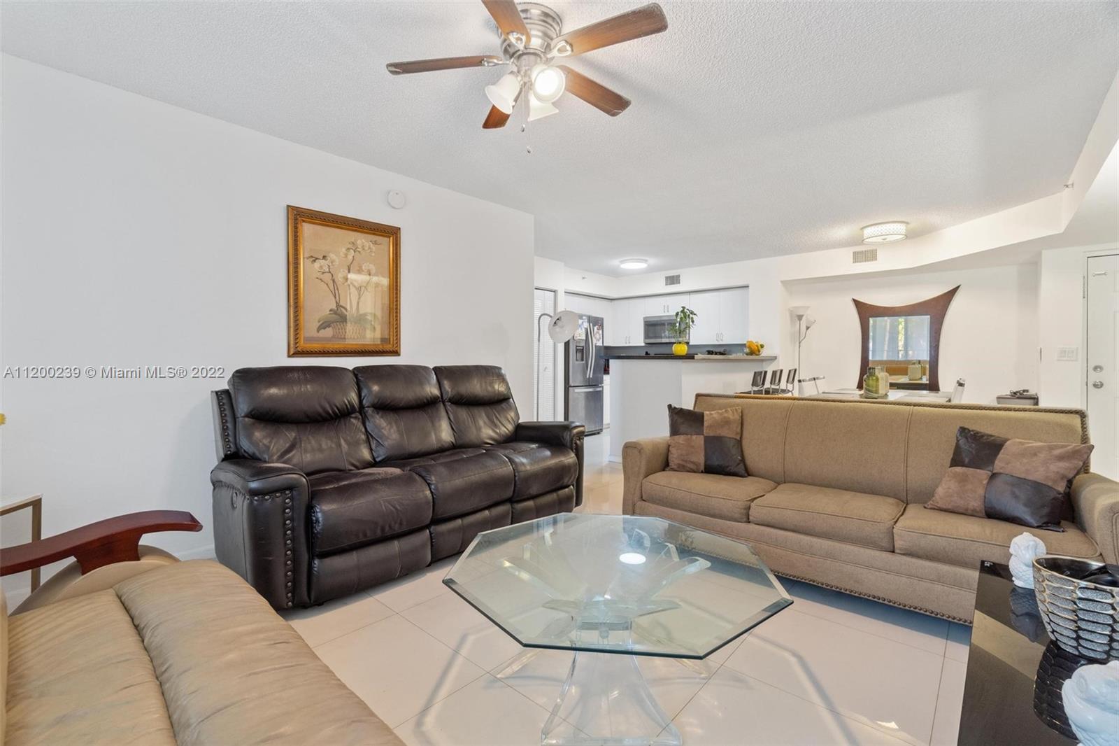 2071 Renaissance Boulevard, Unit 203 Miramar, FL 33025 - Photo 8 of 17 a living room with couches and a view of kitchen