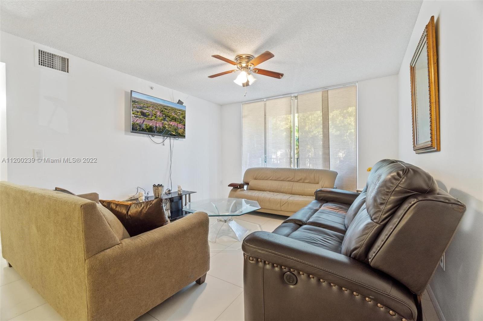 2071 Renaissance Boulevard, Unit 203 Miramar, FL 33025 - Photo 9 of 17 a living room with furniture and a window
