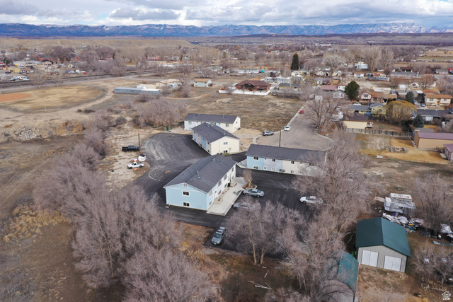 102 East Richelman Lane Wellington, UT 84542 - Photo 3 of 39 Aerial view of property's location featuring a mountain backdrop and nearby suburban area