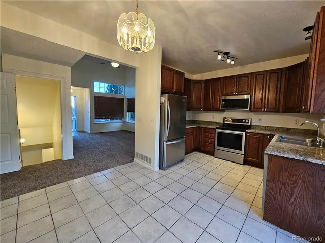 a kitchen with stainless steel appliances granite countertop a stove refrigerator and cabinets