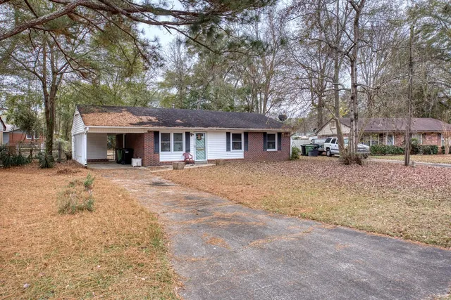 a front view of a house with a yard and trees