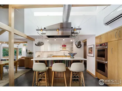a kitchen with stainless steel appliances a table chairs and a refrigerator