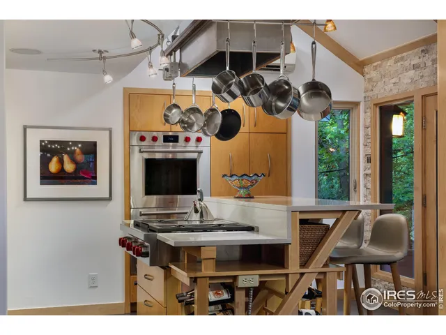 a kitchen with a stove a counter space a sink and dining table with wooden floor