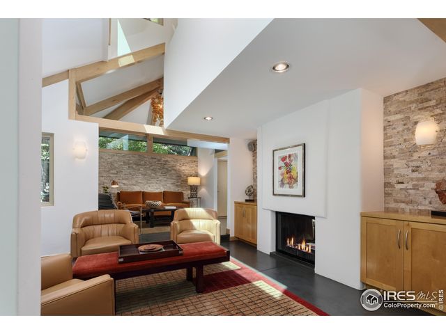 a living room with furniture a large window and a fireplace