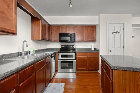 a kitchen with stainless steel appliances granite countertop a sink stove and refrigerator