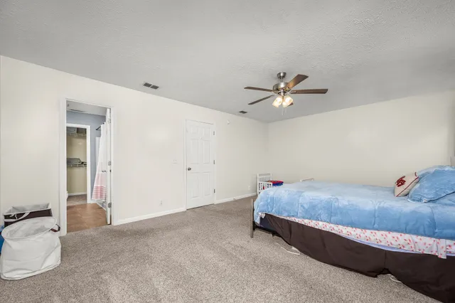 a bedroom with a bed and a ceiling fan