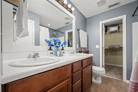 a bathroom with a sink toilet double vanity and shower