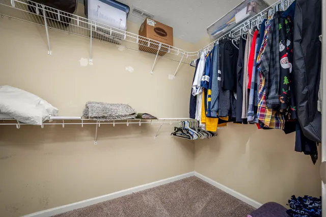 a view of walk in closet with clothes and shoes
