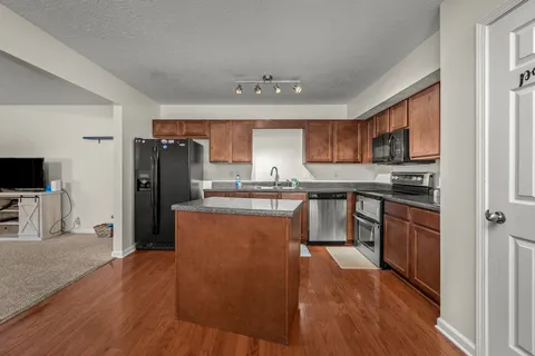 a kitchen with stainless steel appliances granite countertop a refrigerator stove top oven and sink