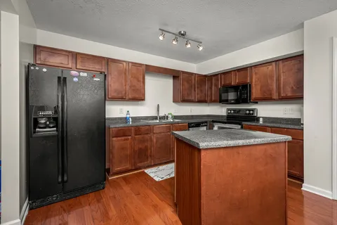 a kitchen with stainless steel appliances granite countertop a refrigerator a stove a sink and a microwave