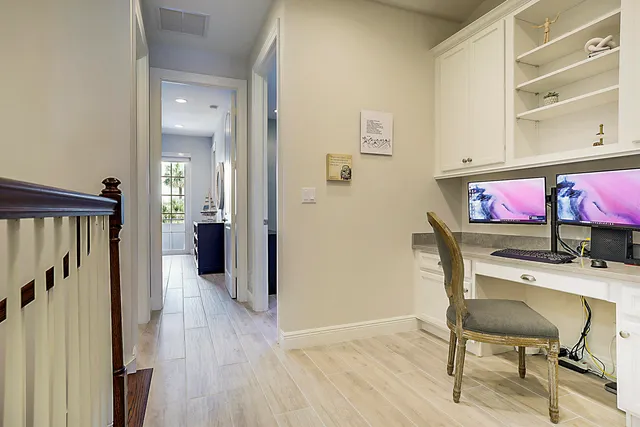 a view of a hallway with wooden floor and furniture