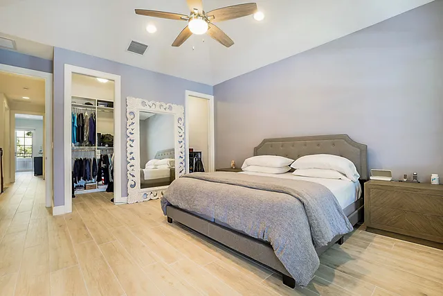 a spacious bedroom with a bed and lamp