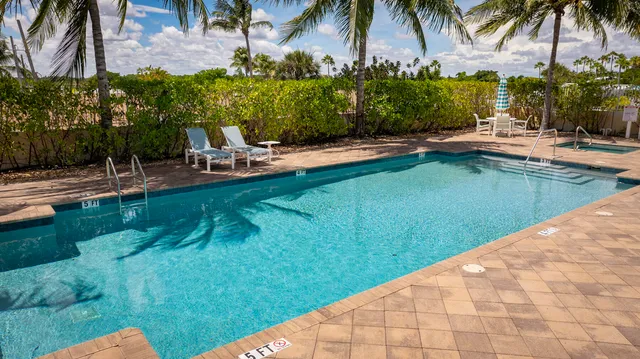 a view of swimming pool with a garden and patio