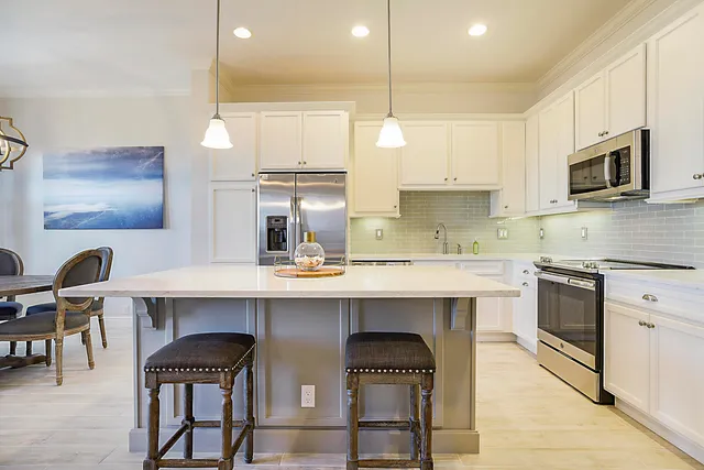 a kitchen with cabinets and chairs
