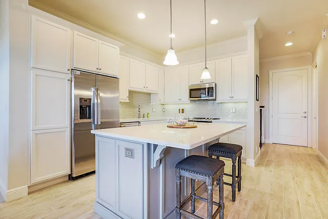 a kitchen with kitchen island a sink stove and refrigerator