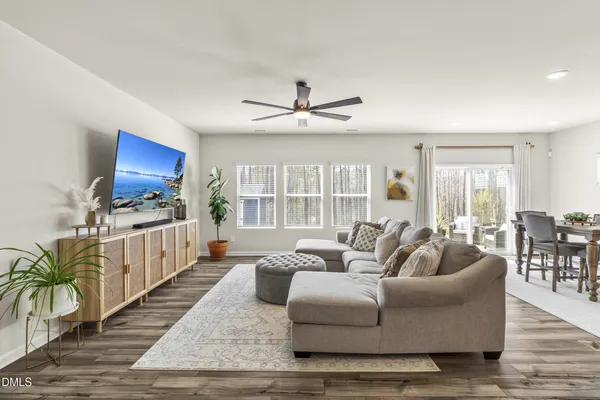 a living room with furniture a flat screen tv and a floor to ceiling window