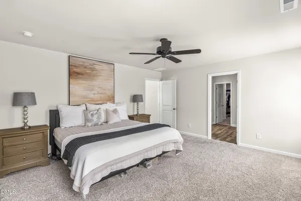 a spacious bedroom with a bed and a chandelier