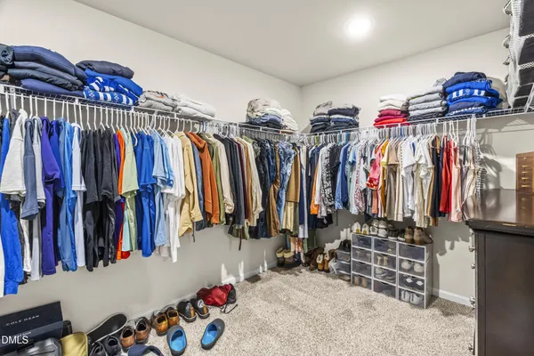 a view of walk in closet with clothes