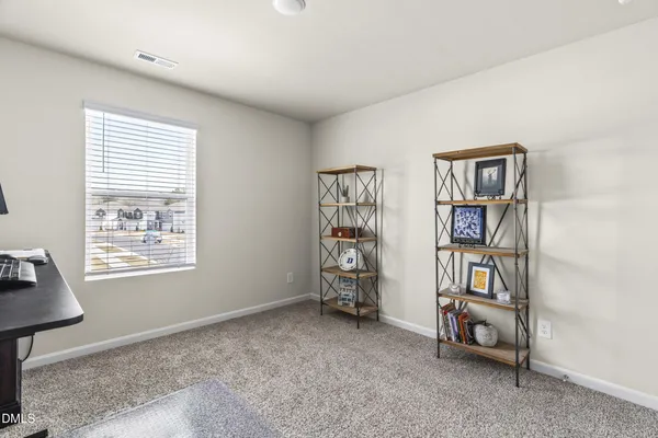 a view of an empty room with window and workspace