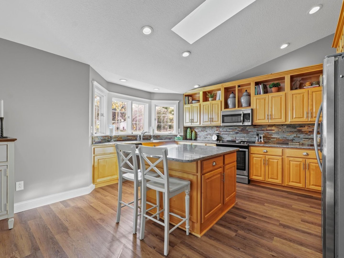 13 Prairie Acres Monticello, IL 61856 - Photo 16 of 53 a kitchen with stainless steel appliances granite countertop wooden cabinets a stove a sink and a large window