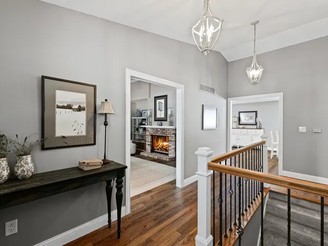 a view of hallway with wooden floor and chandelier