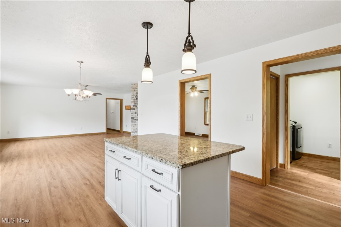 476 Garrison Road Ashtabula, OH 44004 - Photo 32 of 50 Kitchen featuring white cabinetry, ceiling fan with notable chandelier, light hardwood / wood-style floors, hanging light fixtures, and stone countertops