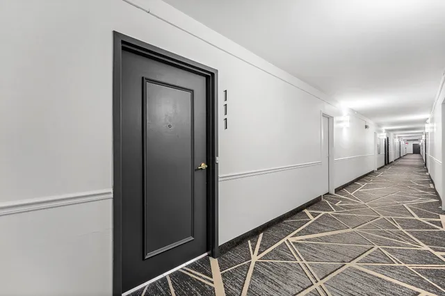 a view of a hallway with wooden cabinets
