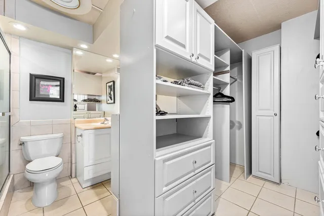 a bathroom with a toilet a sink a mirror a vanity and shower