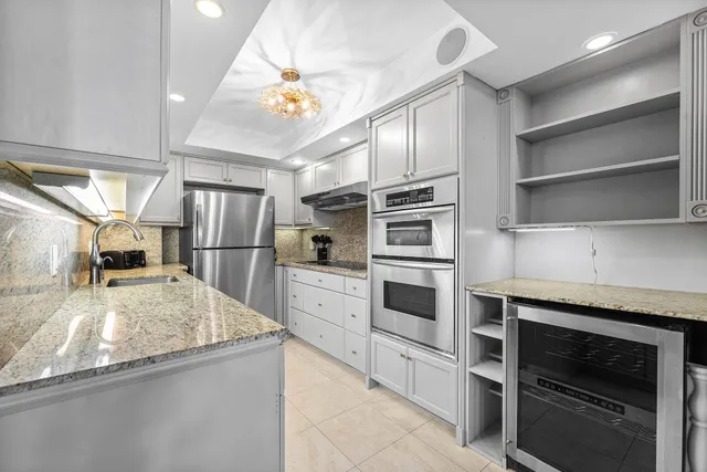 a kitchen with stainless steel appliances granite countertop a refrigerator and a sink