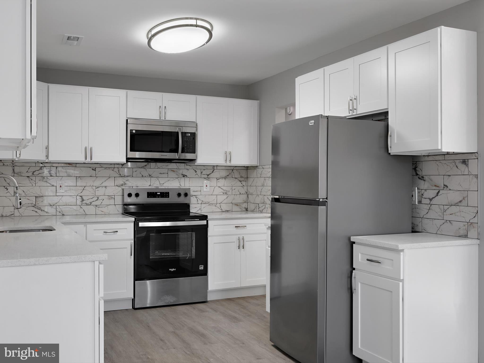 8635 Emory Grove Road Gaithersburg, MD 20877 - Photo 2 of 38 a kitchen with a refrigerator stove and microwave