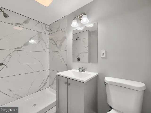 a bathroom with a toilet a sink and mirror